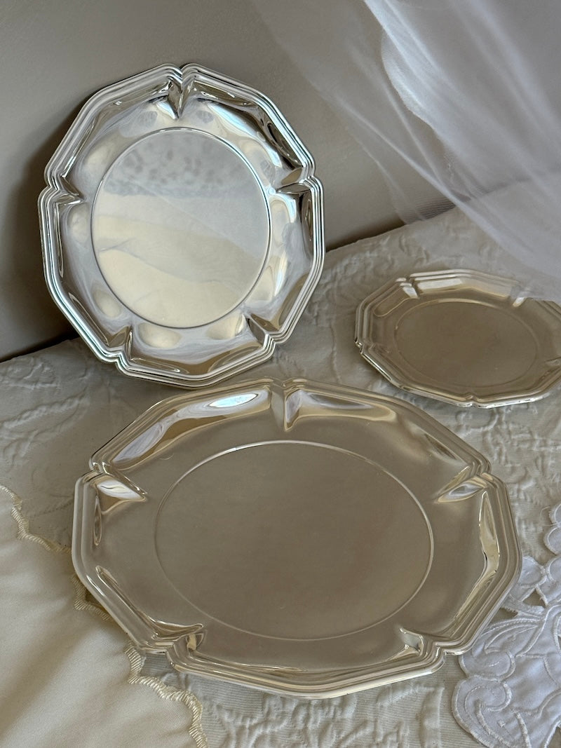 Set of silver platters on a textured surface