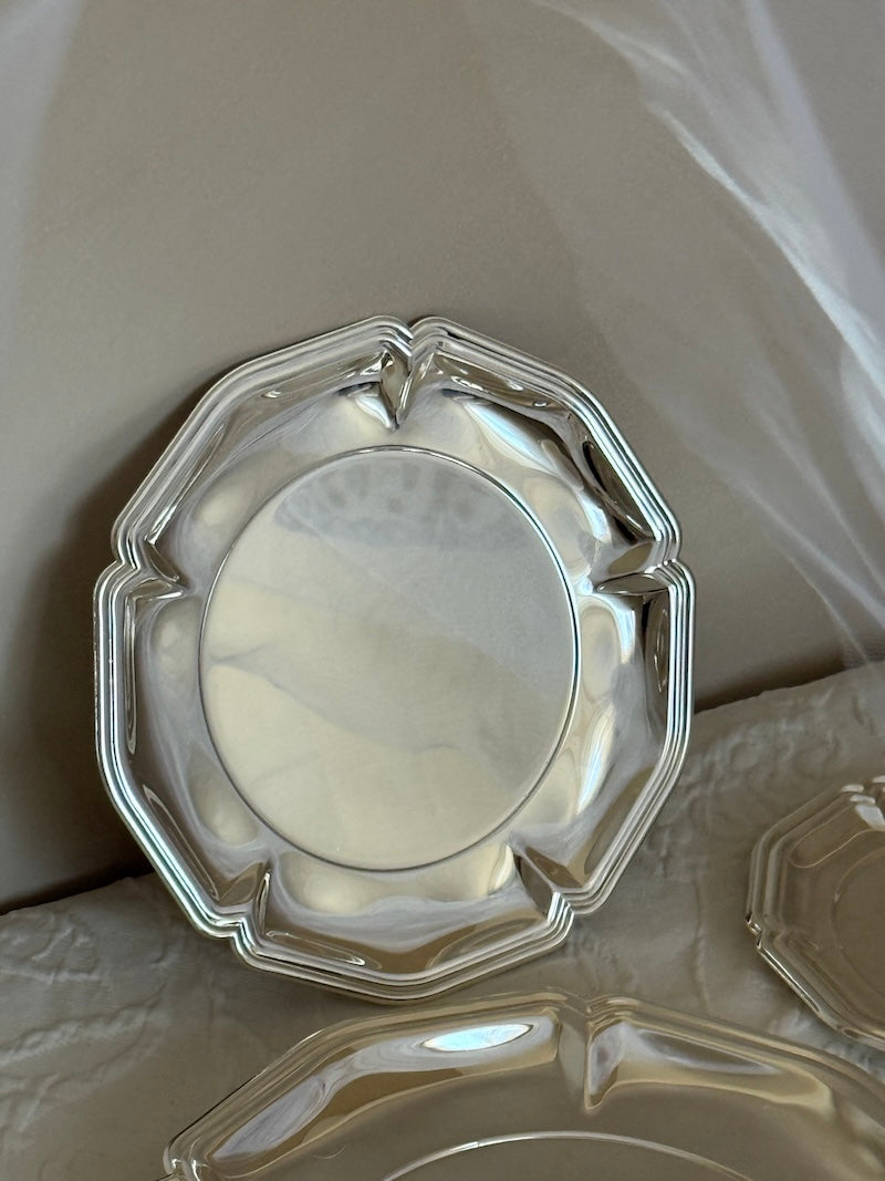 Silver decorative plate on a textured surface