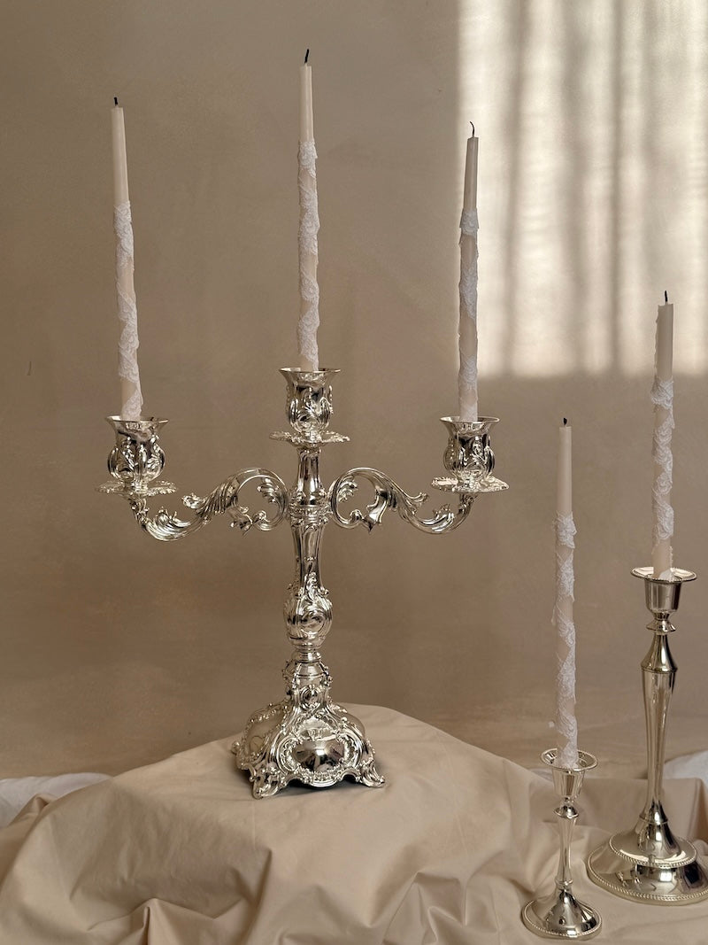 Silver candelabra with four candle holders on a neutral background